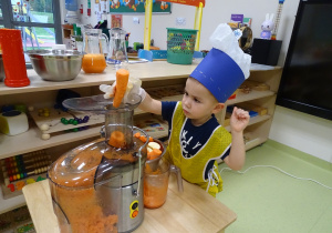 14 Chłopiec wkłada marchew do sokowirówki
